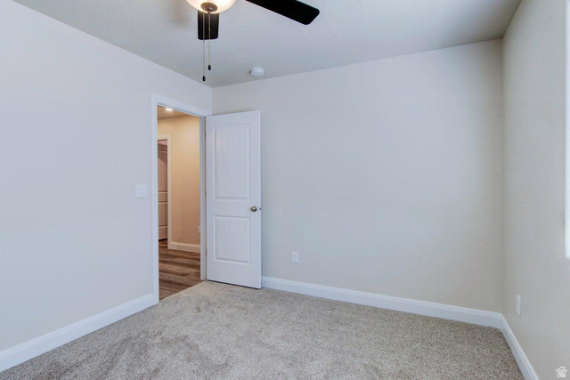 668 East Fiddlers Canyon Road, Unit 24 Cedar City, UT 84721 - Photo 12 of 21 Empty room with light colored carpet and ceiling fan