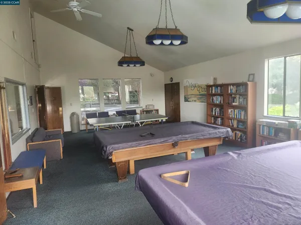 a living room with stainless steel appliances furniture a chandelier open kitchen view