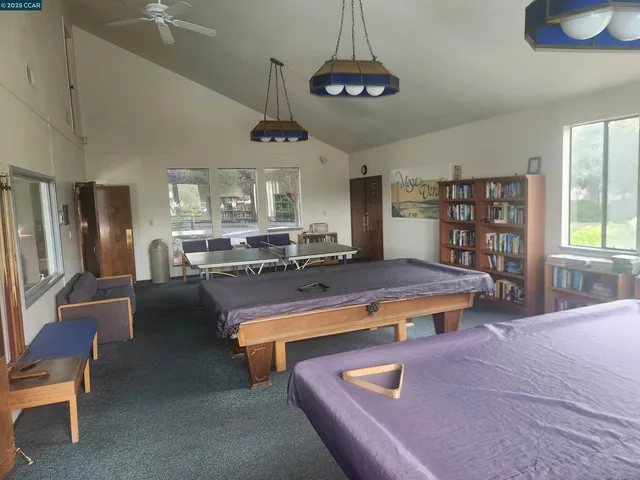 a living room with stainless steel appliances furniture a chandelier open kitchen view