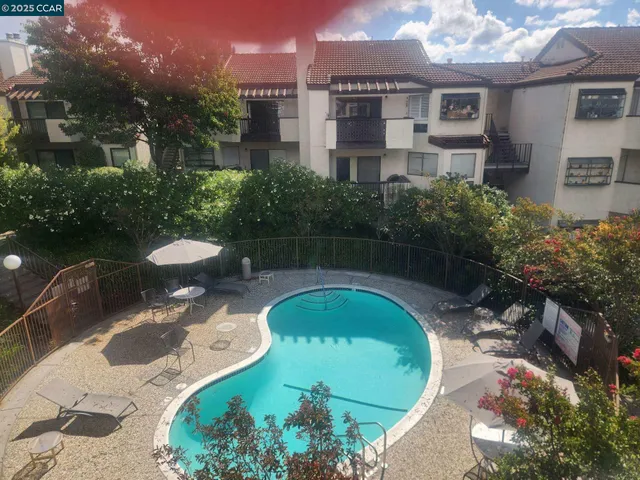 a view of a swimming pool with a patio and a yard