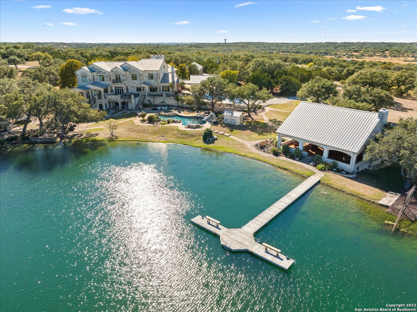 an aerial view of residential houses with outdoor space and lake view