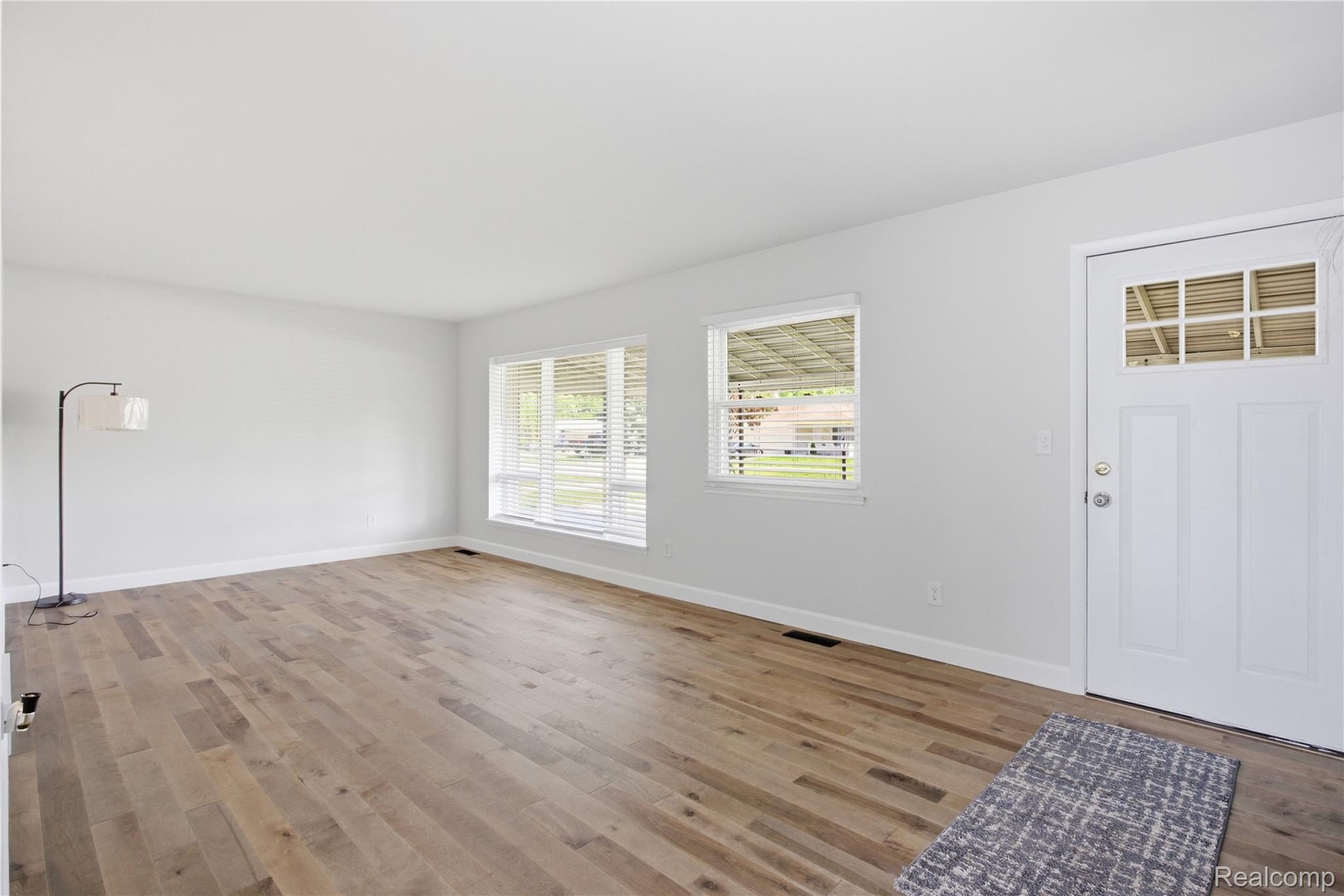37257 Dundee Street Sterling Heights, MI 48310 - Photo 6 of 47 Bright living area featuring wood-finish flooring, white baseboards, and light gray wall tones