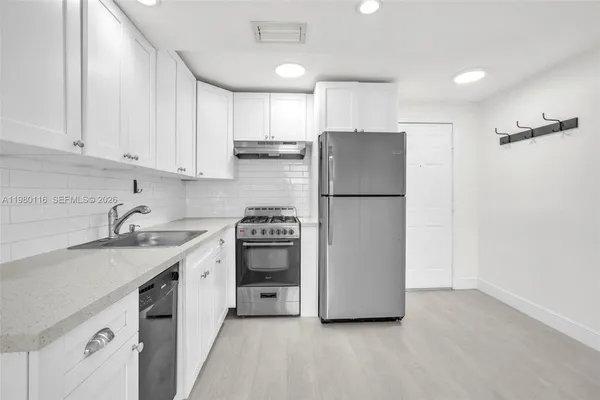 a kitchen with a refrigerator sink and cabinets