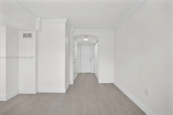 a view of an empty room with closet and a window
