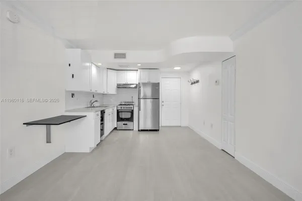 a view of kitchen with stainless steel appliances refrigerator oven and cabinets