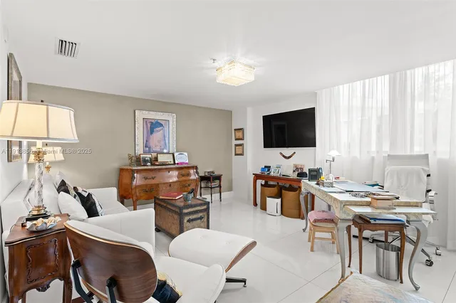 a living room with furniture a chandelier and a view of kitchen
