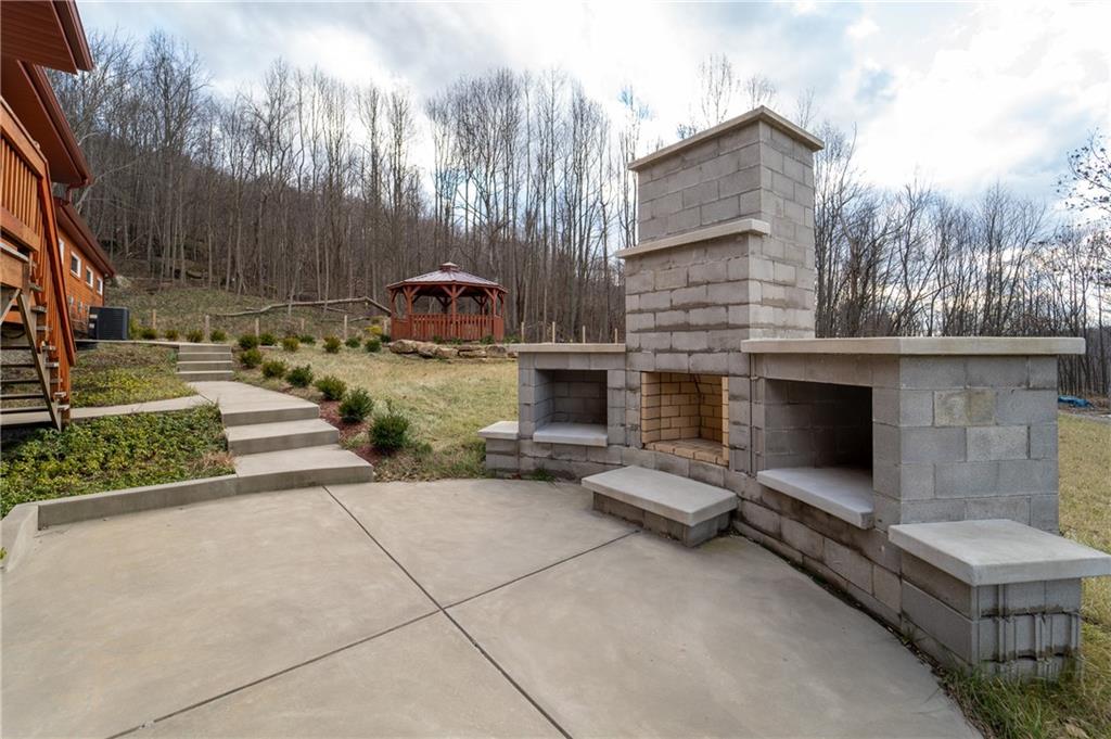 337 Chestnut Ridge Road Latrobe, PA 15650 - Photo 24 of 25 a view of a patio with a table and a fireplace