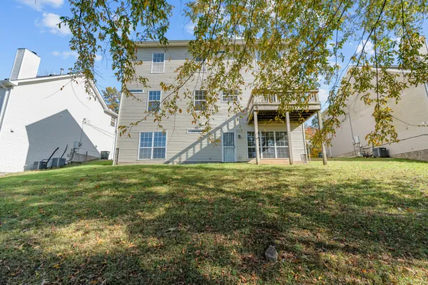 an empty room with windows a fireplace and wooden floor