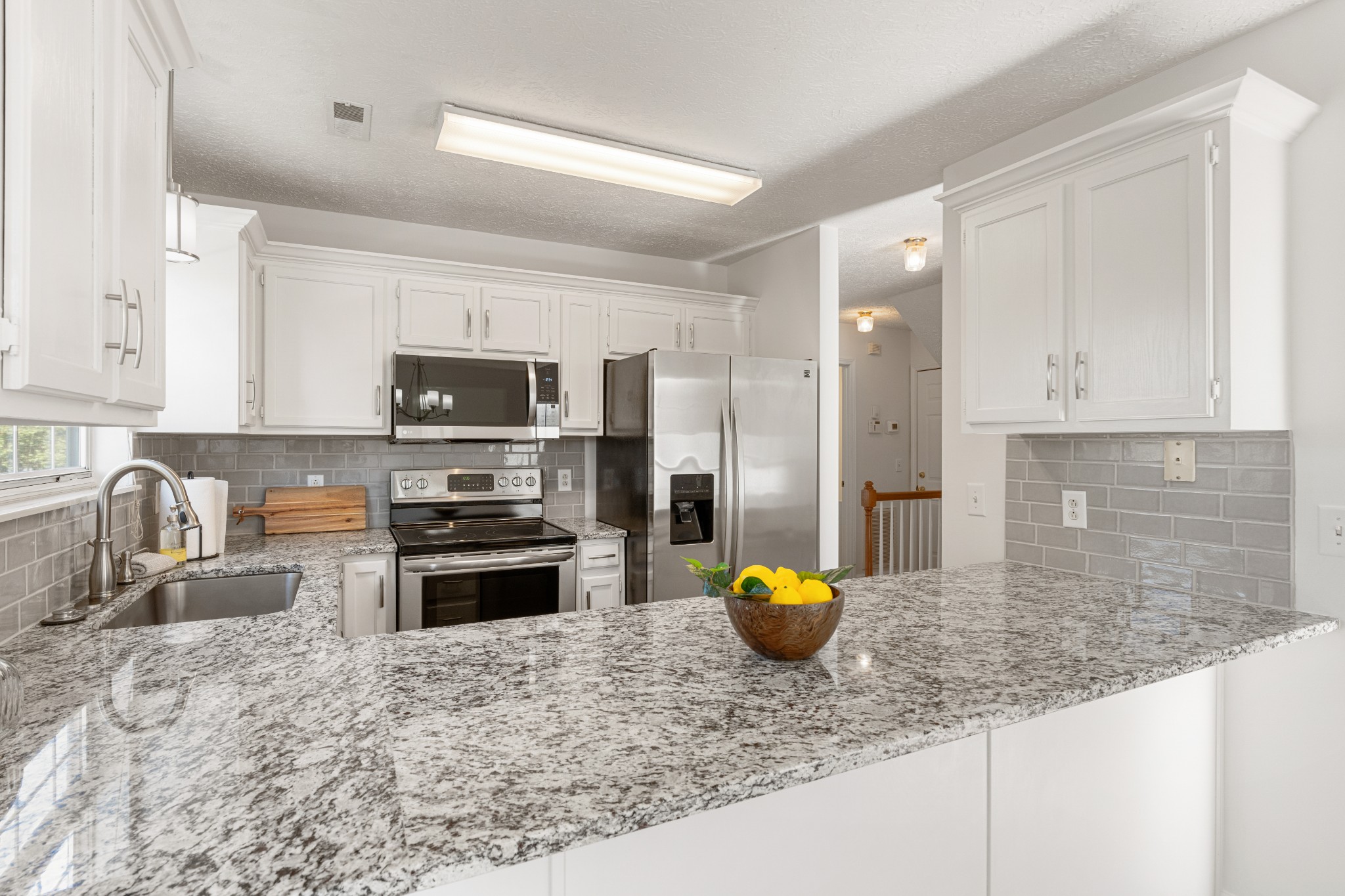 1068 Tulip Grove Road Hermitage, TN 37076 - Photo 42 of 100 a kitchen with stainless steel appliances granite countertop a stove a sink a microwave a refrigerator a stove and white cabinets