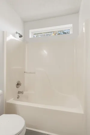 an empty room with wooden floor and a ceiling fan