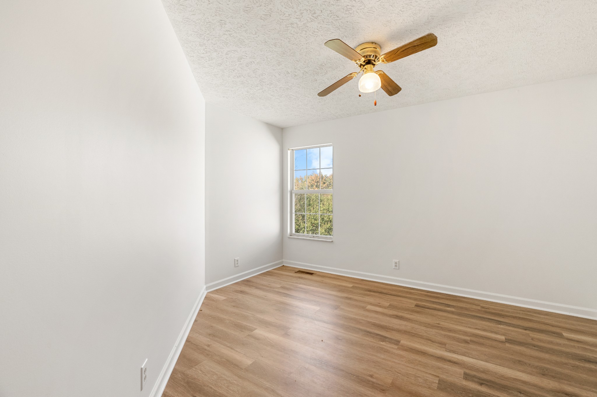 1068 Tulip Grove Road Hermitage, TN 37076 - Photo 90 of 100 an empty room with wooden floor and ceiling fan
