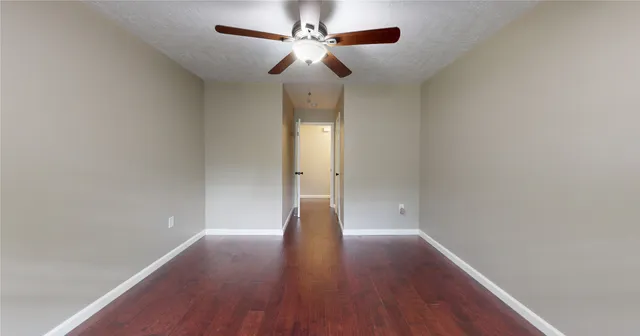 a view of wooden floor and a chandelier fan in a room
