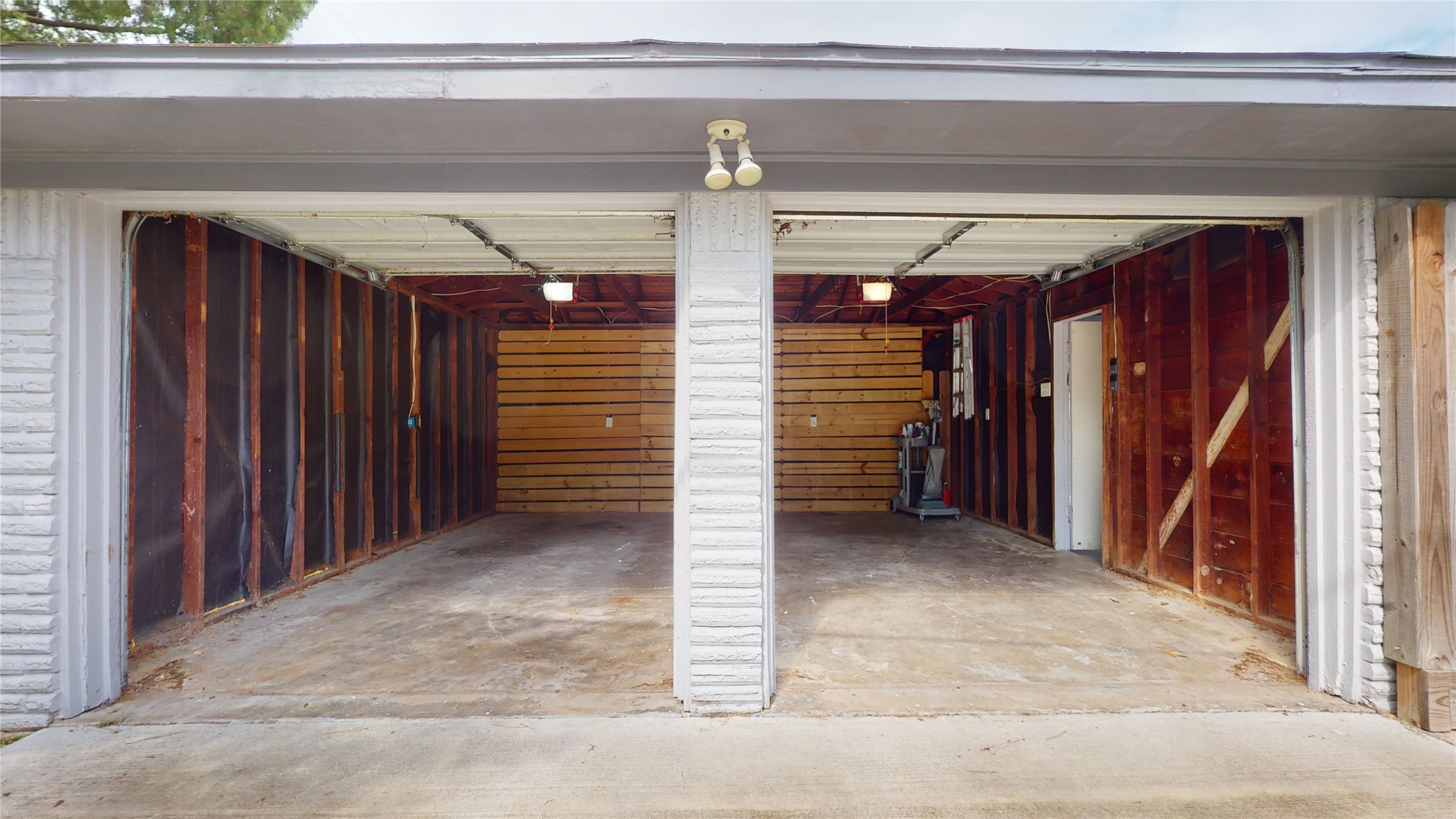 4803 Sanford Road Houston, TX 77035 - Photo 28 of 28 Garage with two automatic garage doors (opened in this picture). Please note the pedestrian entrance to the fenced backyard on the right side of the picture.
