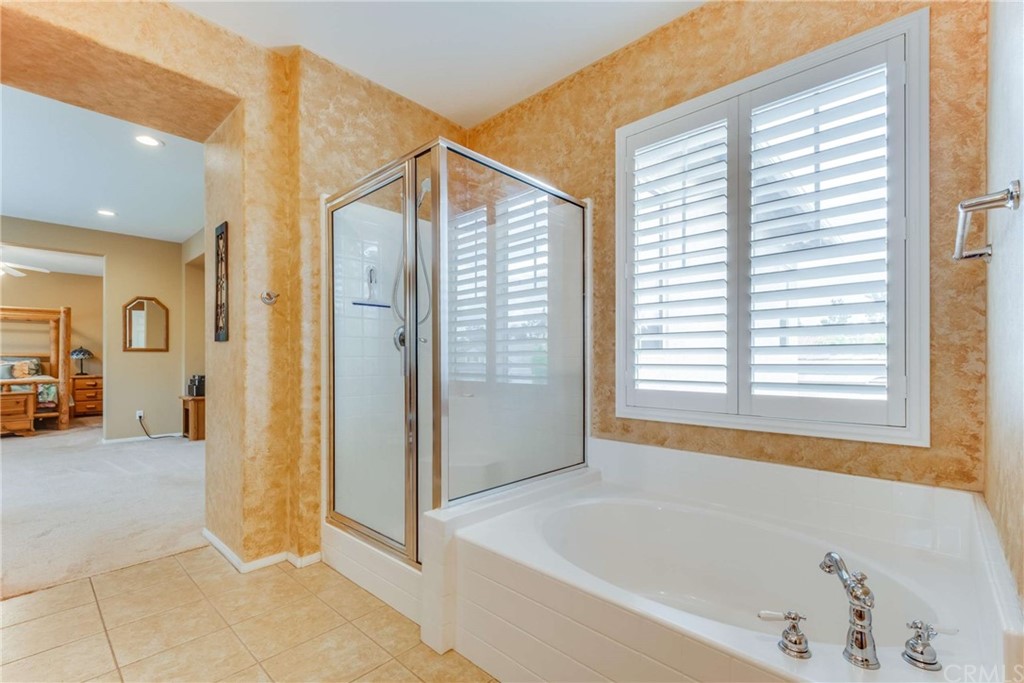 23537 Cantara Road Corona, CA 92883 - Photo 44 of 60 a bathroom with a bathtub and a shower