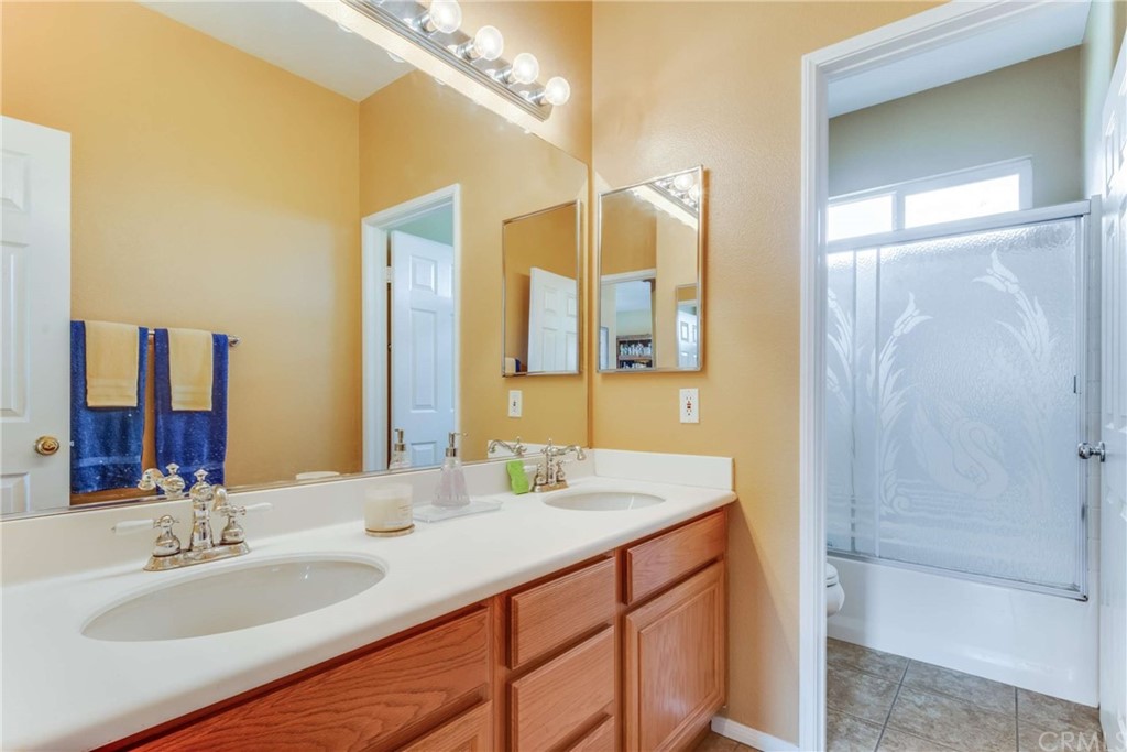 23537 Cantara Road Corona, CA 92883 - Photo 47 of 60 a bathroom with a double vanity sink mirror and shower