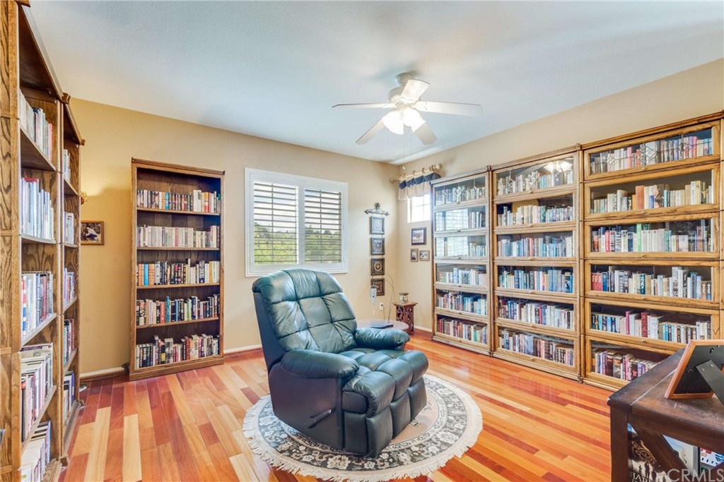 23537 Cantara Road Corona, CA 92883 - Photo 49 of 60 a living room with furniture and a book shelf