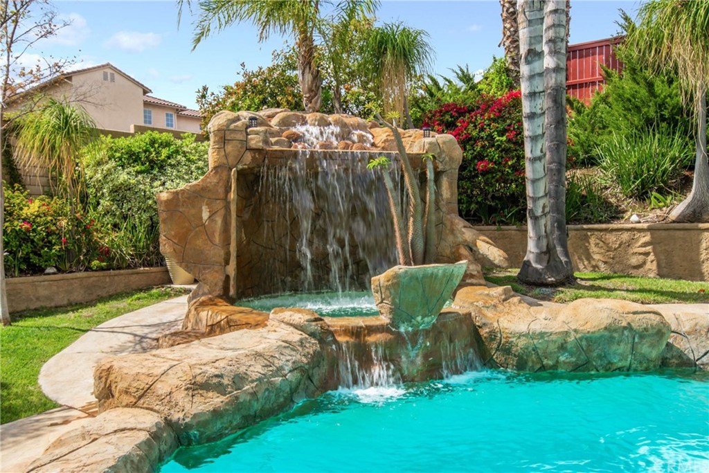 23537 Cantara Road Corona, CA 92883 - Photo 53 of 60 a backyard of a house with table and chairs under an umbrella
