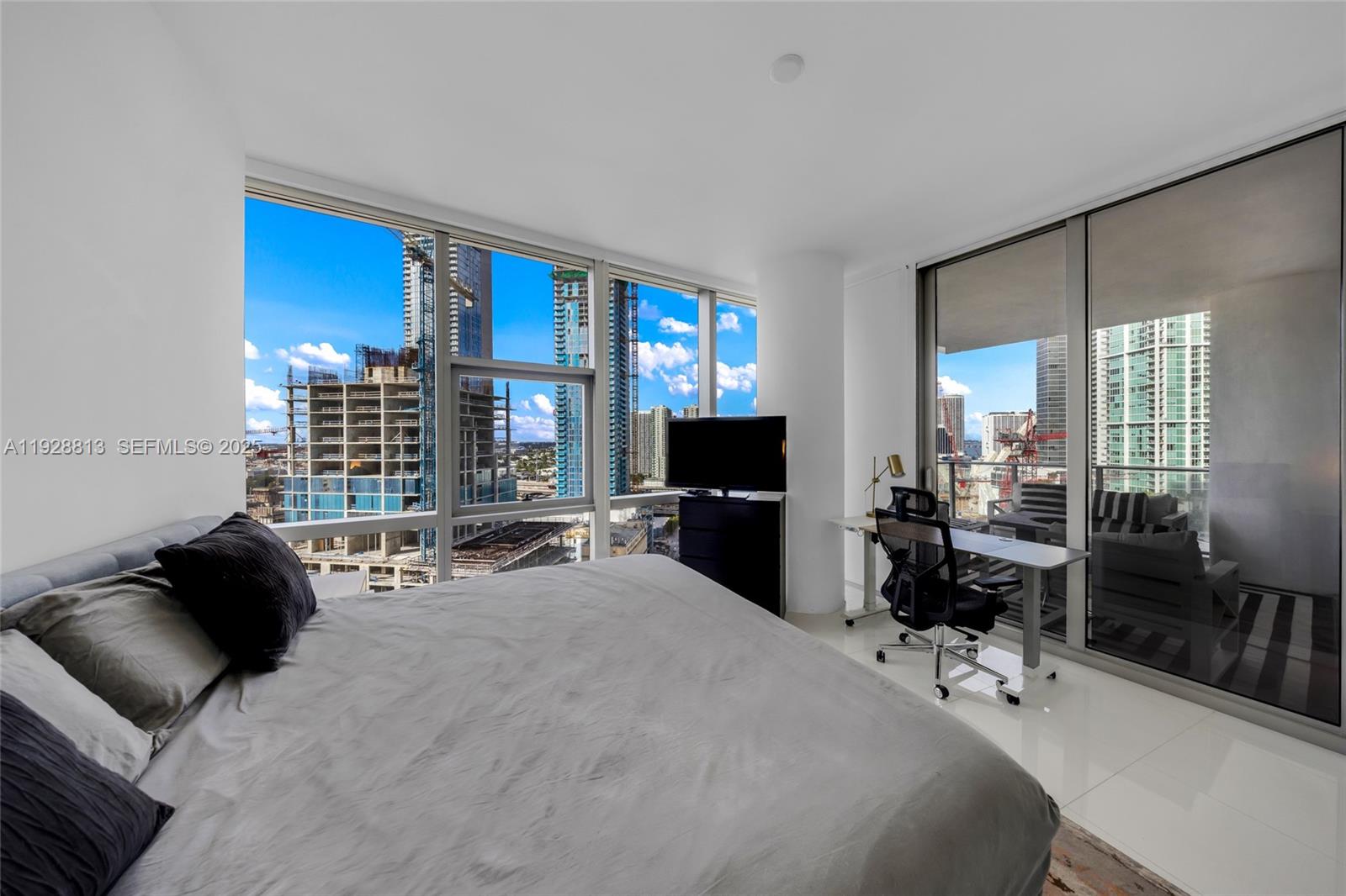 851 Northeast 1st Avenue, Unit 1700 Miami, FL 33132 - Photo 19 of 30 a bedroom with a bed couch and a flat tv screen next to a window