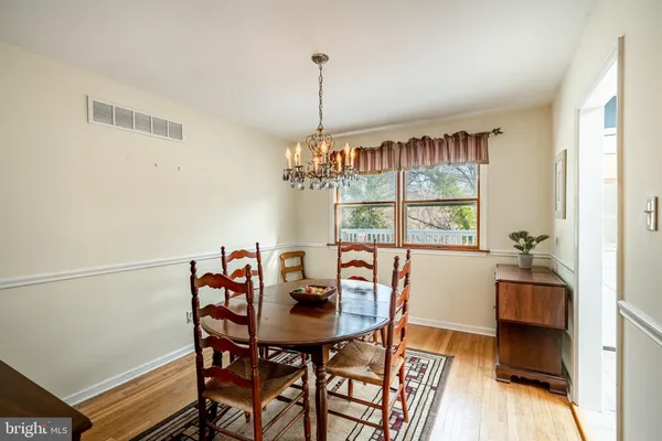 a view of a dining room with furniture a chandelier and wooden floor