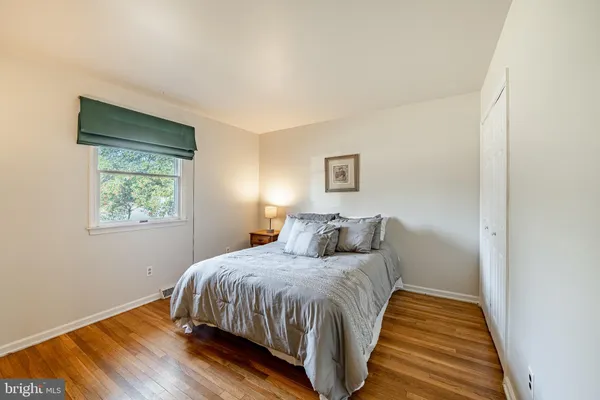 a bedroom with a bed and a wooden floor