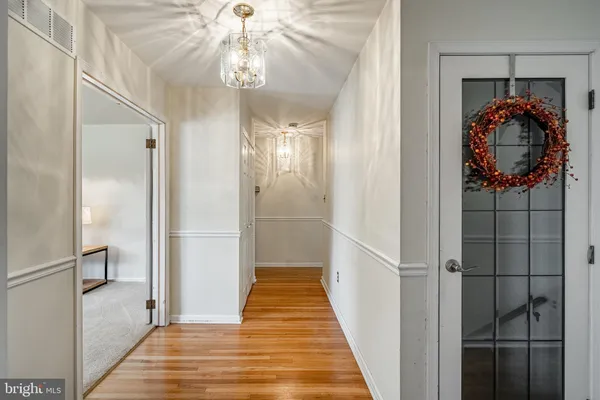 a view of a hallway with wooden floor and staircase
