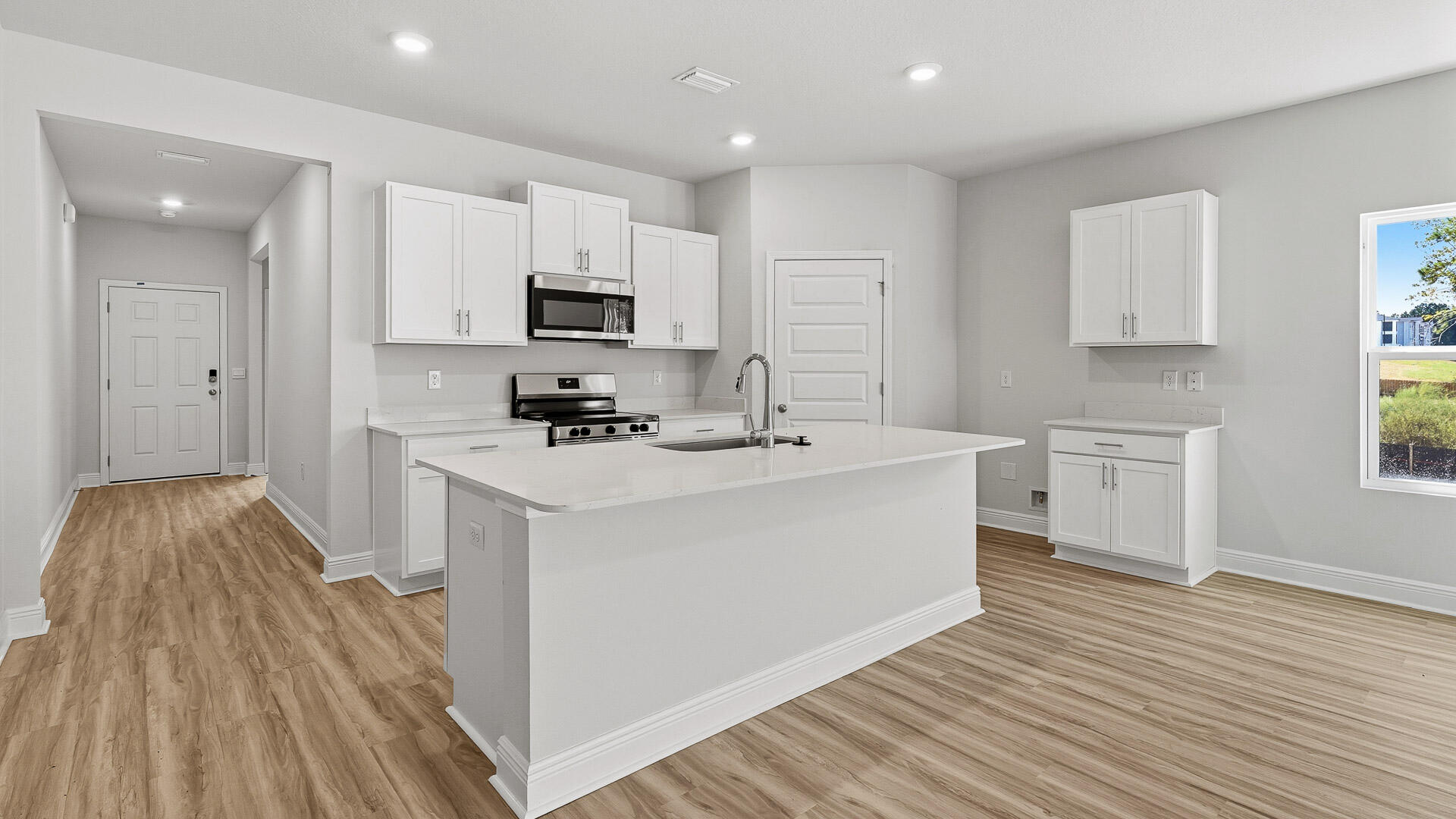2075 Wiregrass Street Navarre, FL 32566 - Photo 2 of 29 a kitchen with white cabinets a sink dishwasher and a stove with wooden floor