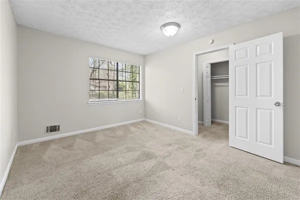 a view of a kitchen with white cabinets and refrigerator