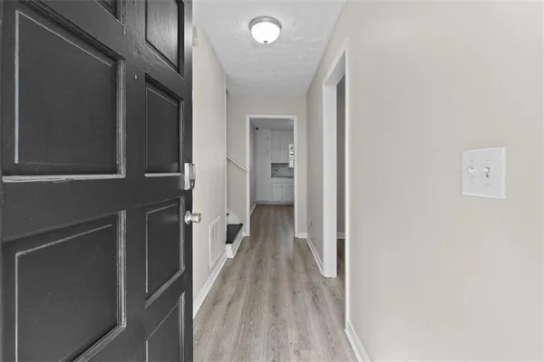 a view of a hallway with wooden floor and staircase