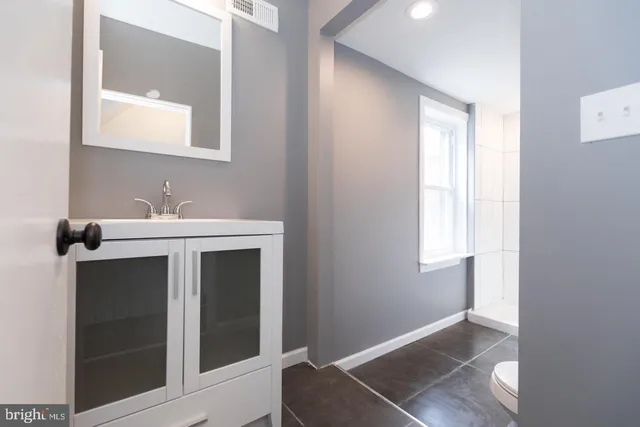 a bathroom with a sink vanity and a mirror