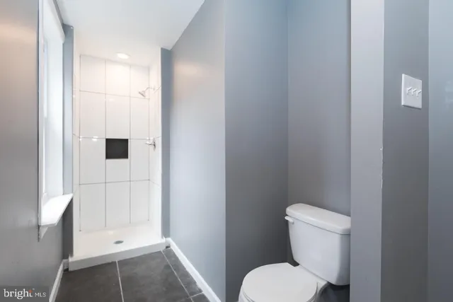 a white toilet sitting next to a bathroom sink