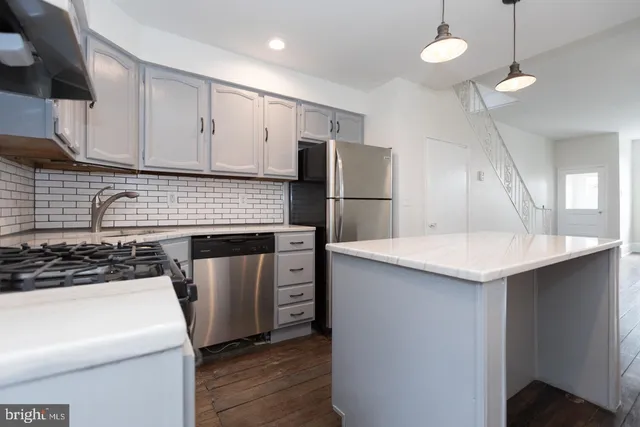 a kitchen with a sink a stove a refrigerator and cabinets