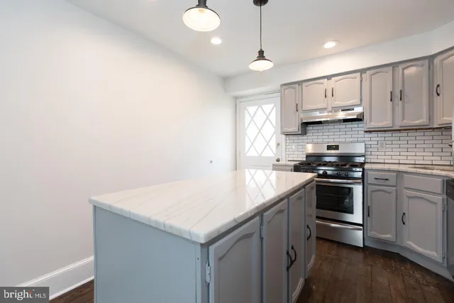 a kitchen with a sink a stove and cabinets