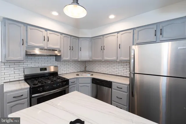 a kitchen with a refrigerator a sink and cabinets