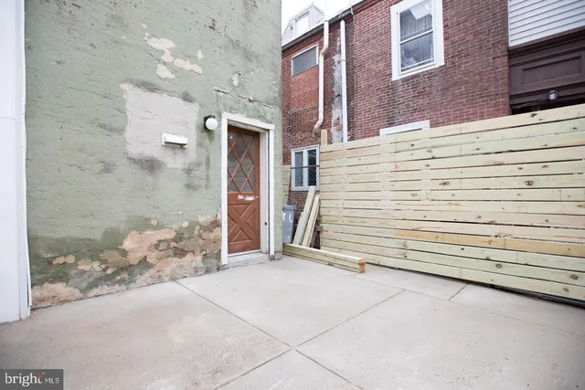 a view of a house with a door and wooden bench
