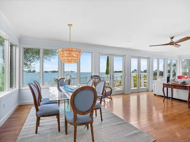 a dining room with furniture a chandelier and wooden floor