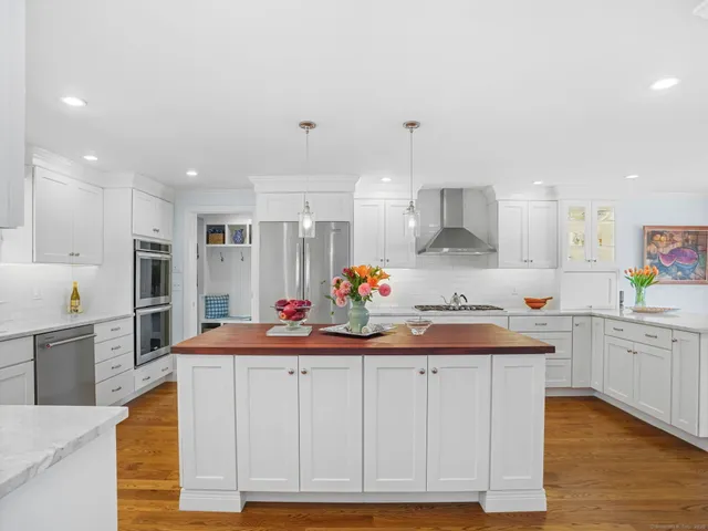 a kitchen with white cabinets and sink