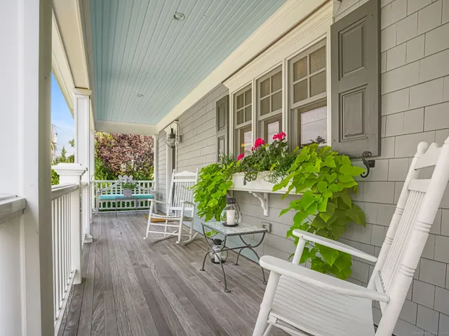 a porch with chairs and wooden floor
