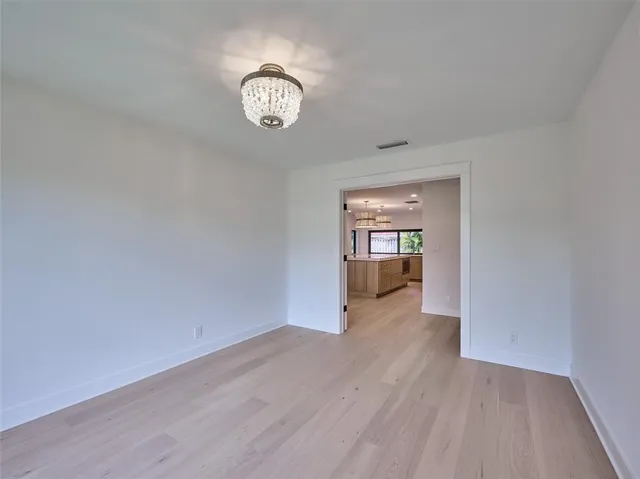 a view of a hallway with wooden floor and a living room