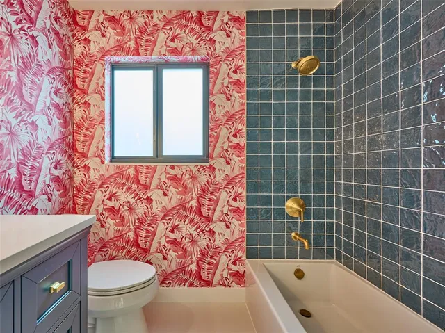a view of an empty room with a window and a kitchen