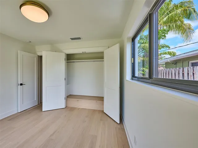 a front view of a house with a garden and trees