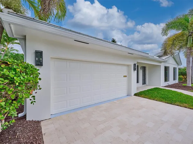 front view of a house with a yard and potted plants