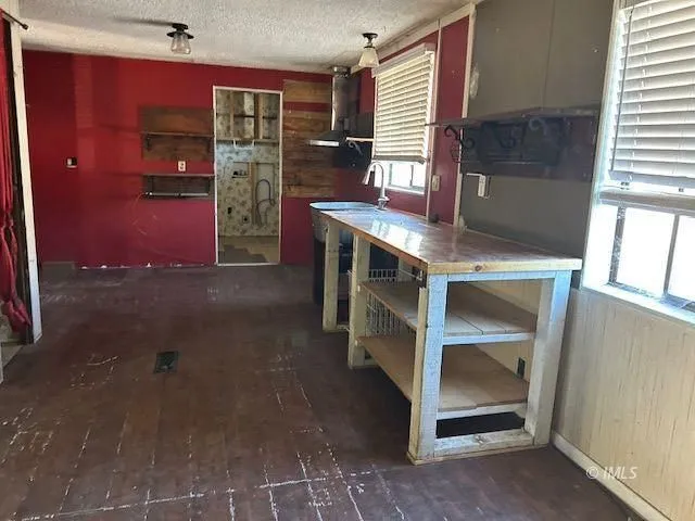 a view of an empty room with furniture and window