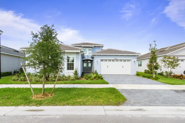 a front view of a house with a yard and garage
