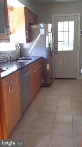 a kitchen with granite countertop a sink a stove and cabinets