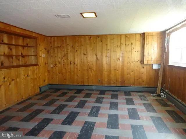 a view of a yard with a large tree and wooden fence