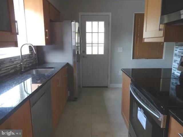 a kitchen with granite countertop a sink stove and cabinets