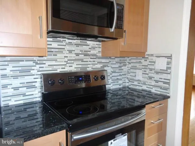 a stove top oven sitting inside of a kitchen
