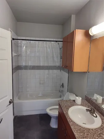 a bathroom with a granite countertop sink toilet and shower