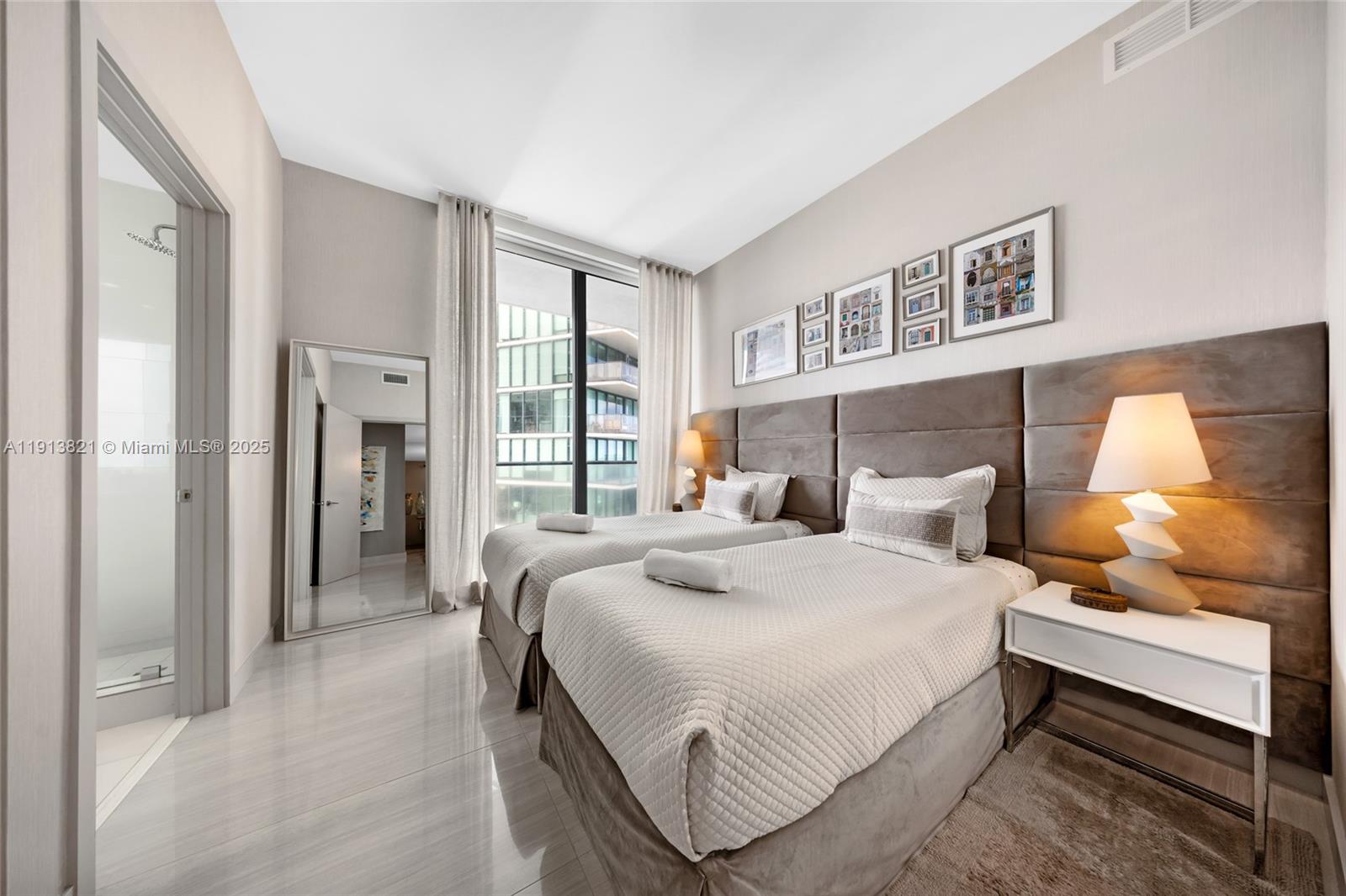 480 Northeast 31st Street, Unit 2807 Miami, FL 33137 - Photo 12 of 45 a bedroom with a bed and a lamp on dresser with wooden floor