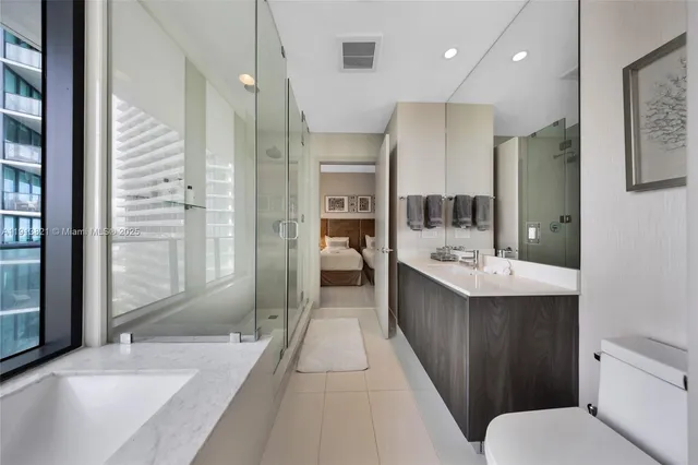 a bathroom with a tub sink shower and mirror